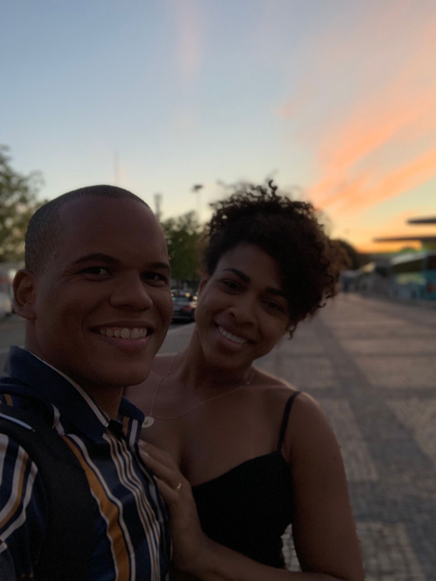 Casal em selfie na orla de Lisboa ao pôr do sol