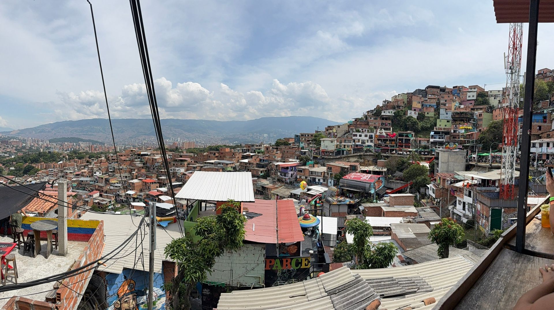Casas coloridas na encosta da Comuna 13, com Medellín ao fundo