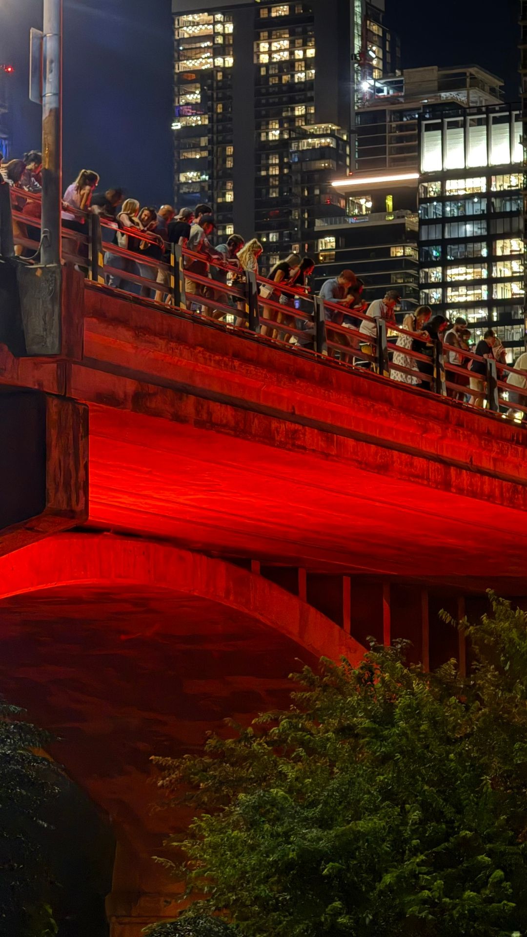 Congress Avenue Bridge iluminada à noite, repleta de observadores, em Austin