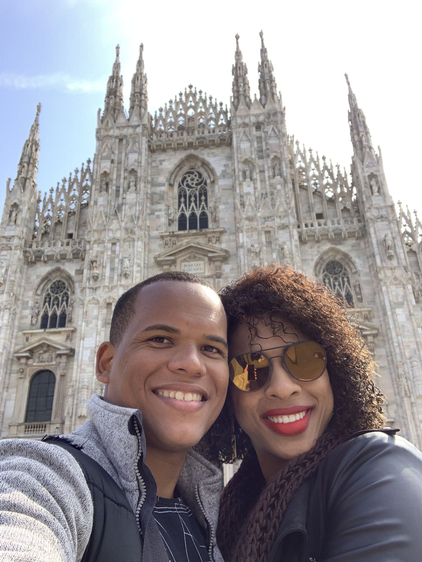 Casal em selfie diante da fachada gótica do Duomo de Milão