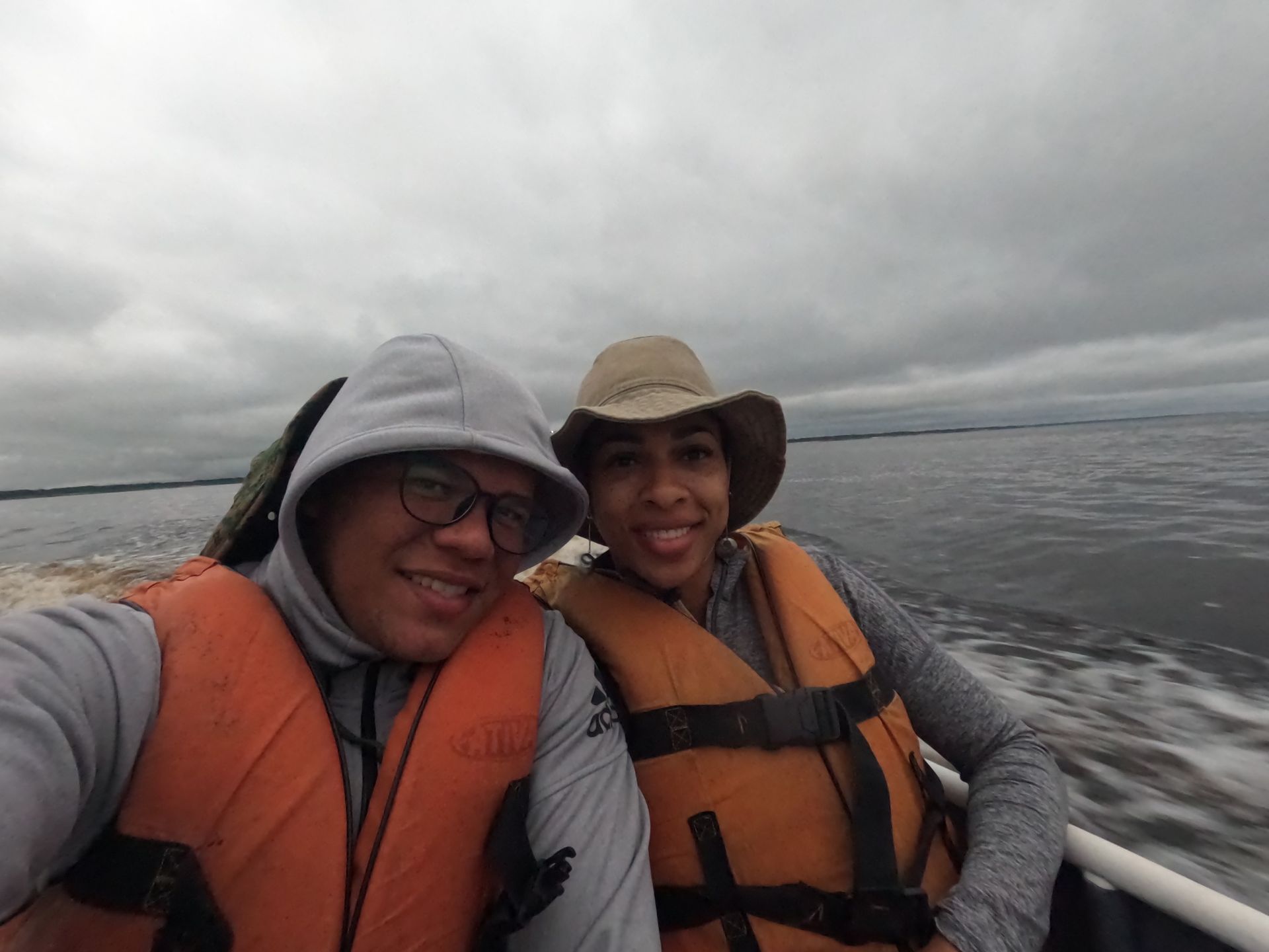 Casal de coletes salva-vidas em barco no Rio Negro