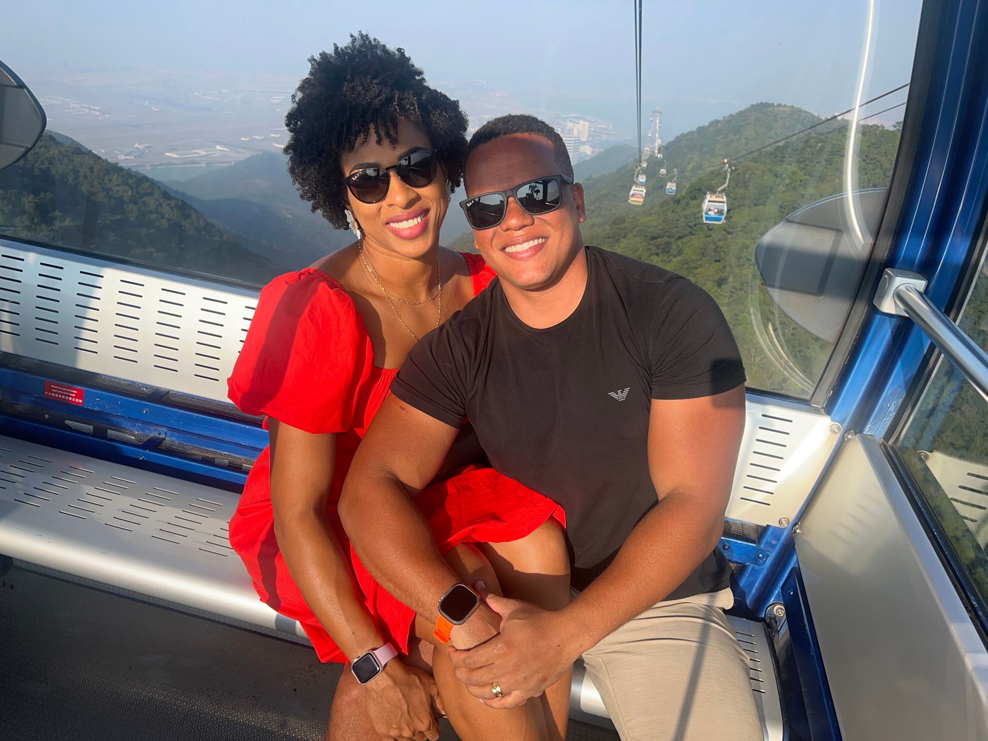Casal no teleférico Ngong Ping 360 com as montanhas de Lantau ao fundo